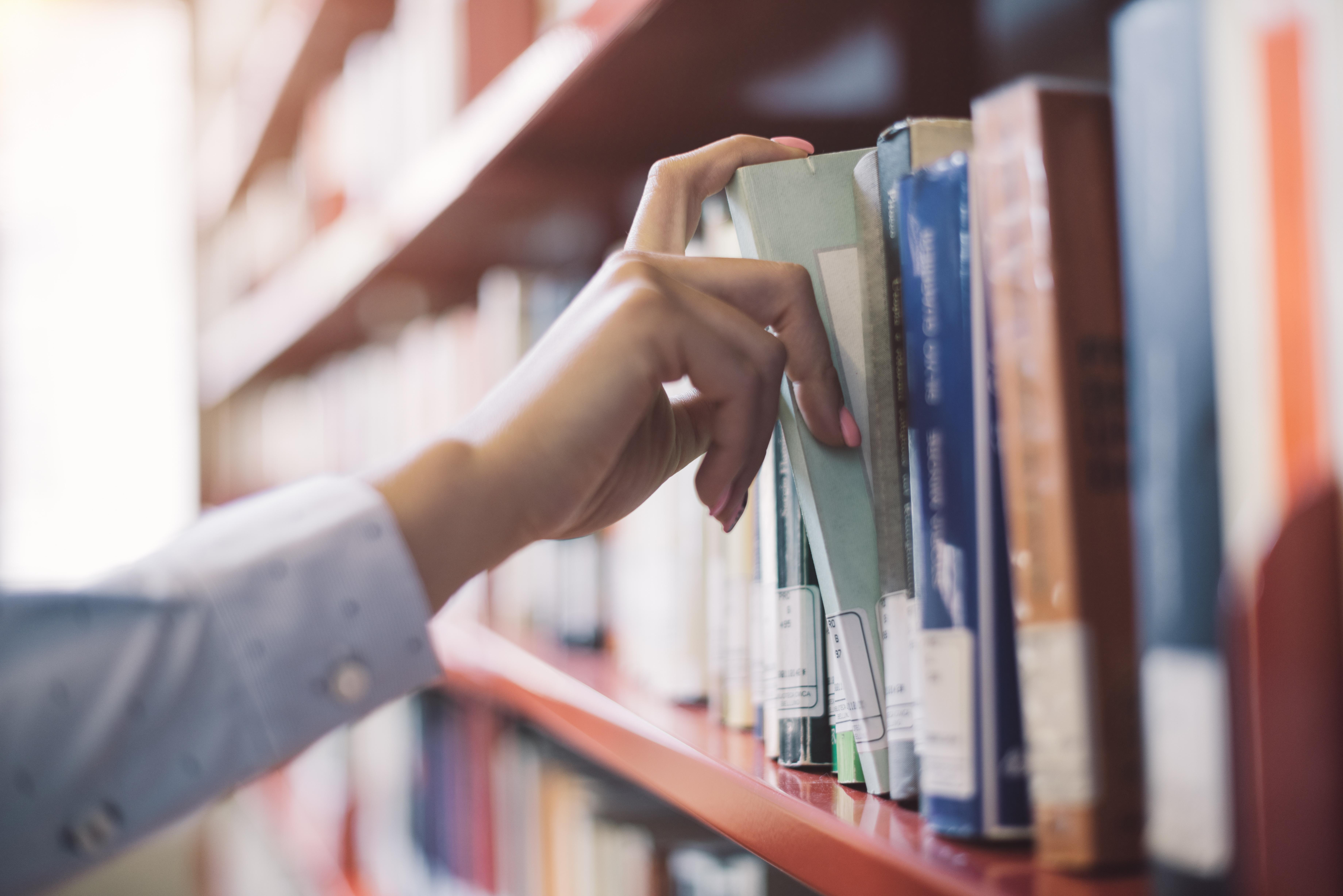 Book being pulled off library shelf