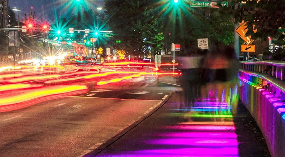 night photograph of college park intersection with lights blurred to show motion