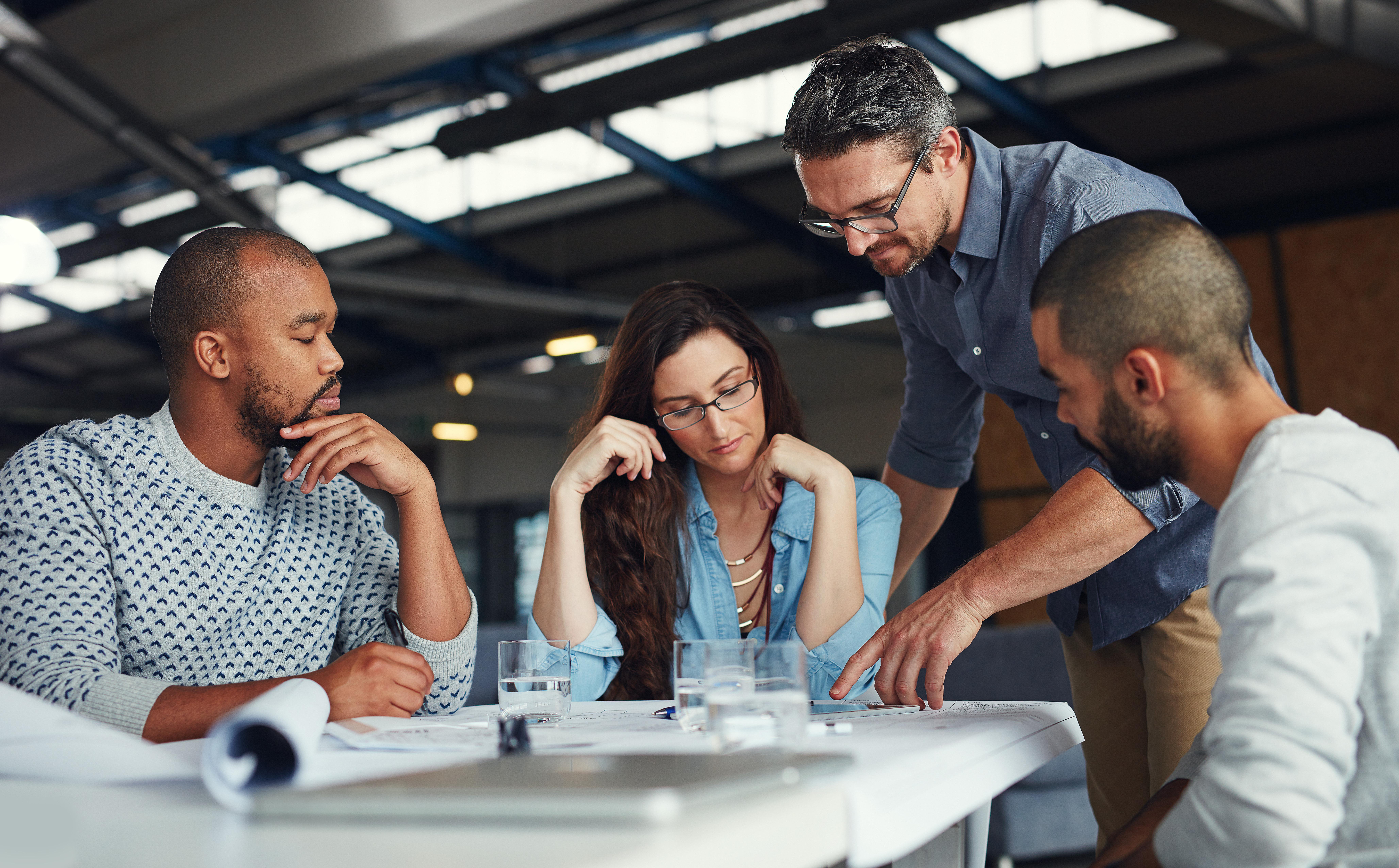 group of employees reviewing references on a table top