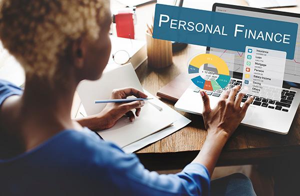 person in front of computer reviewing finances